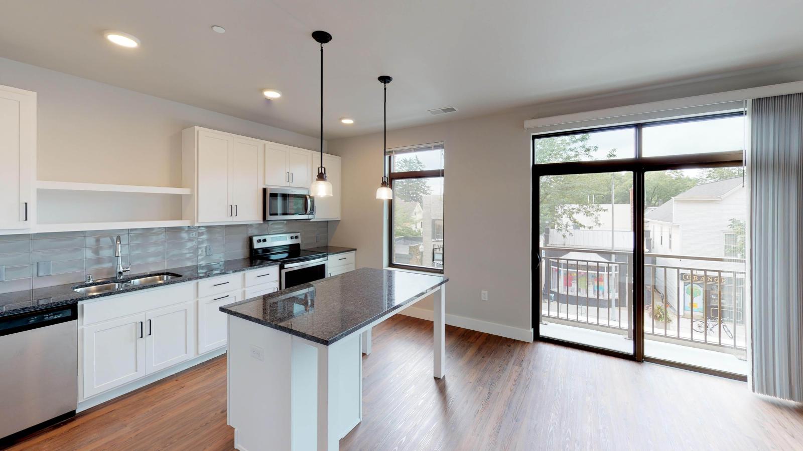 One bedroom with open living and kitchen, and balcony looking neighborhood at 1722 Monroe Apartments in Madison