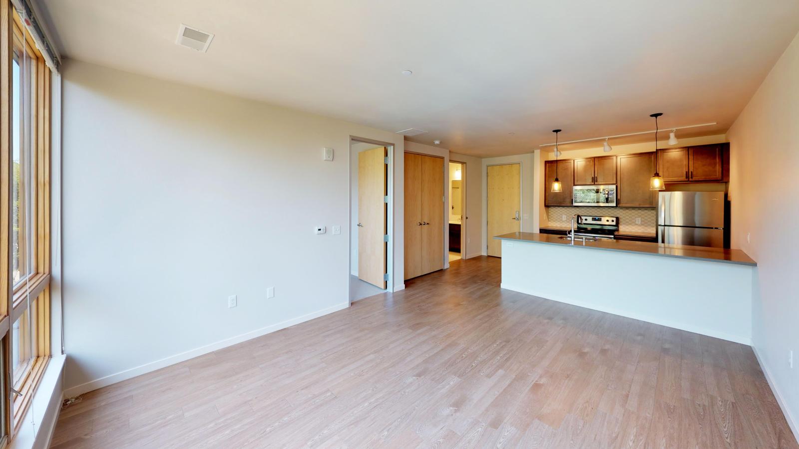 Spacious one-bedroom apartment at Quarter Row Apartments featuring a modern kitchen with quartz countertops and sleek finishes in downtown Madison.
