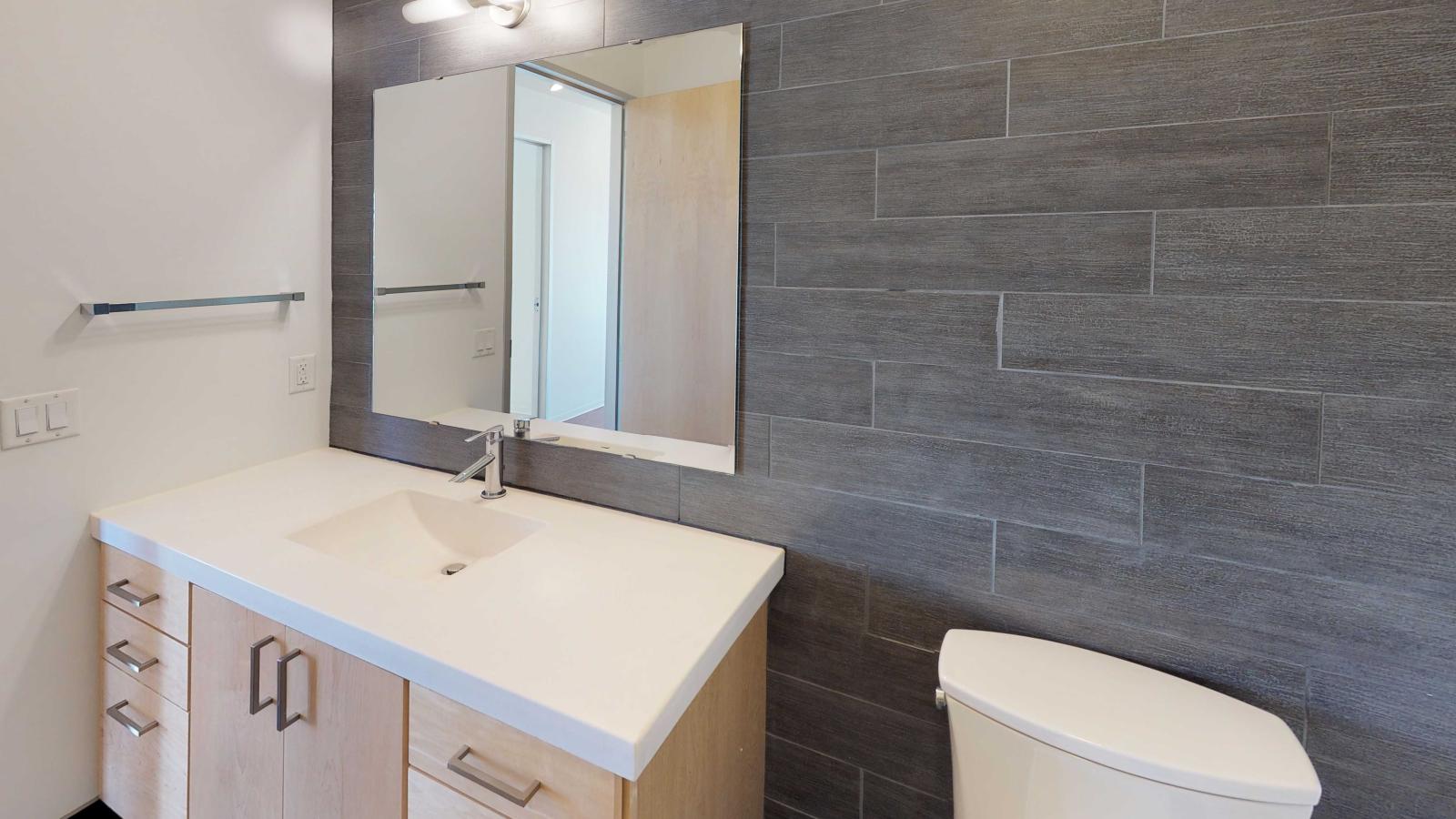 Bathroom featuring a walk in shower with glass doors and contemporary tile at SEVEN27